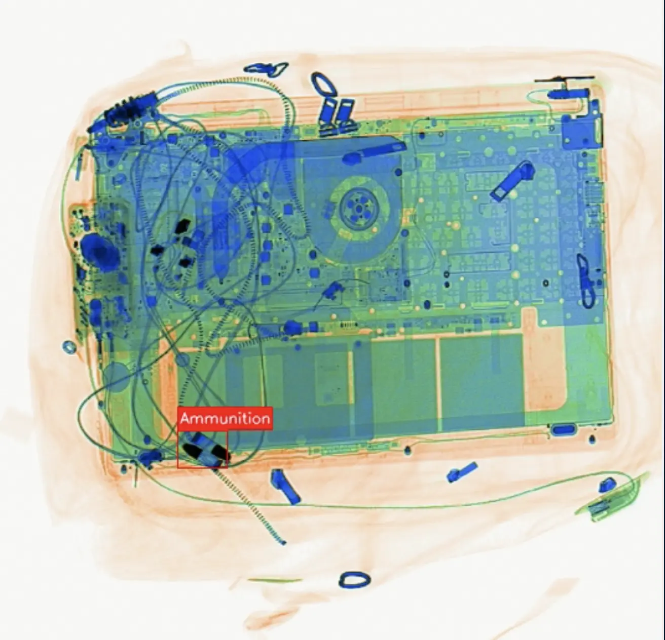 AI X-ray detection flagging ammunition concealed beside a laptop