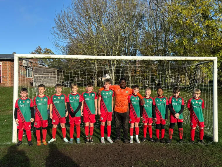 The Ash United youth squad lined up in front of the goal in RedteQ-sponsored kit