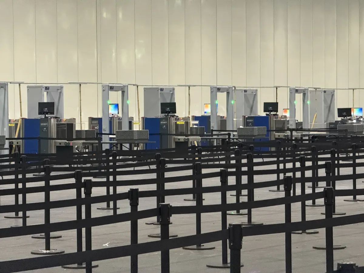 Rows of walk-through metal detectors at a stadium entrance