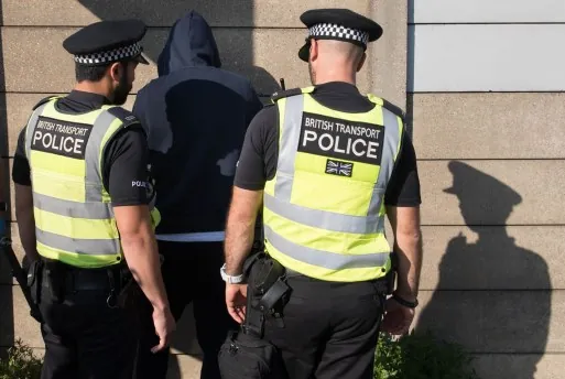 Police officers stopping and searching an individual on the street