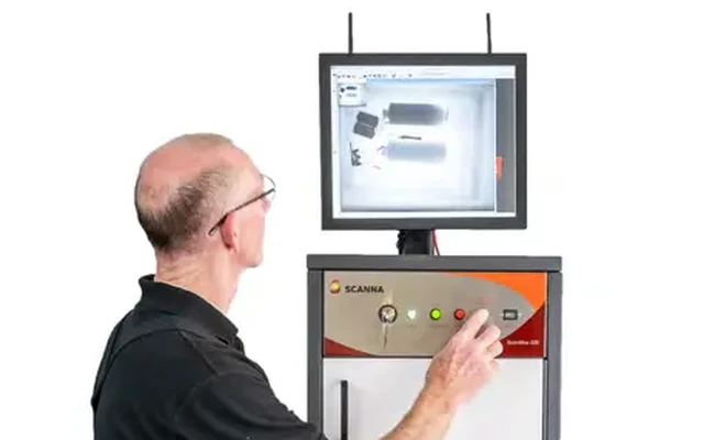 Operator running a cabinet X-ray with the scanned image on screen