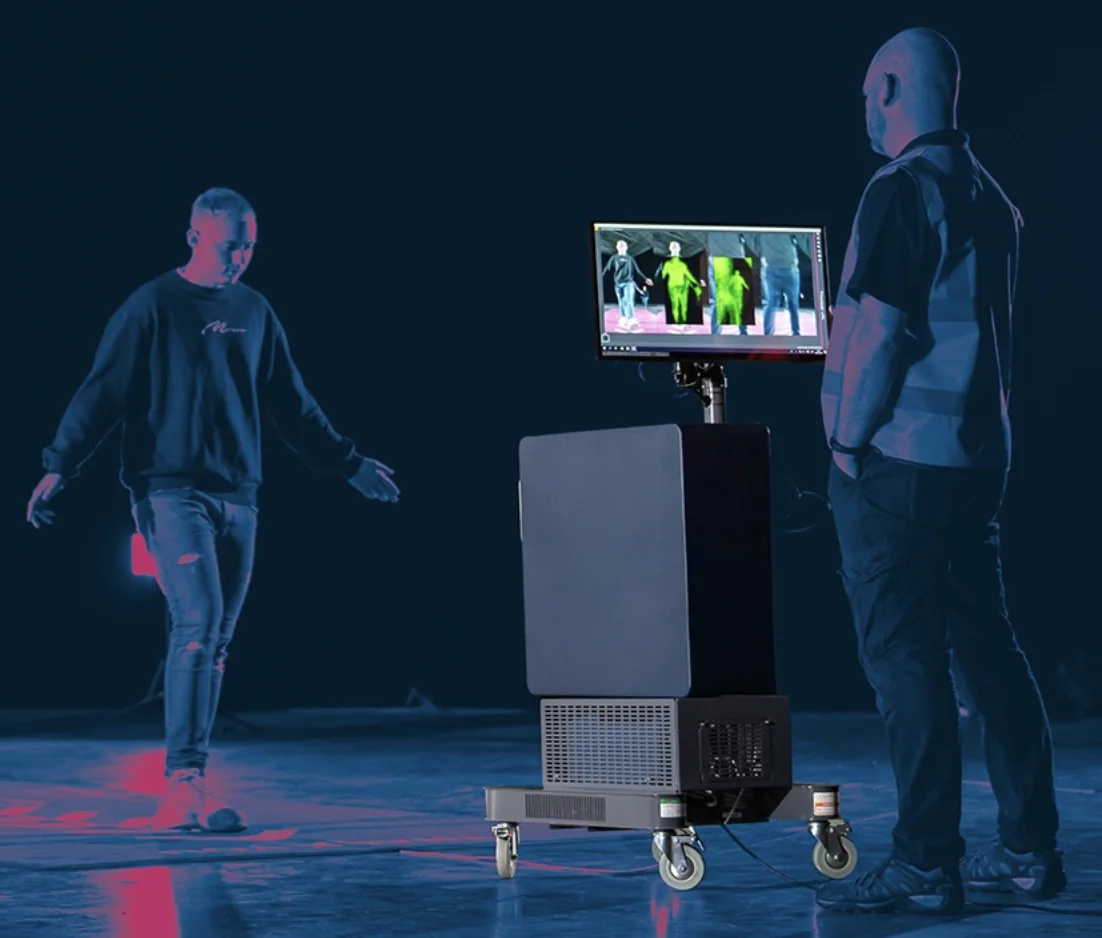 Thruvision 81 Series camera screening a walking subject while an operator watches the live terahertz image